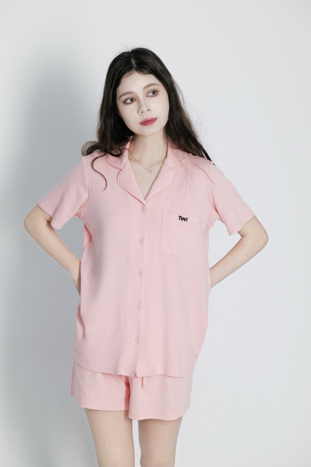 Model wearing pink Tovi sleepwear in a clean studio portrait